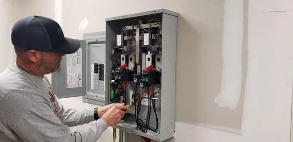 Powerhouse Generator -a man working on a genreator electrical box